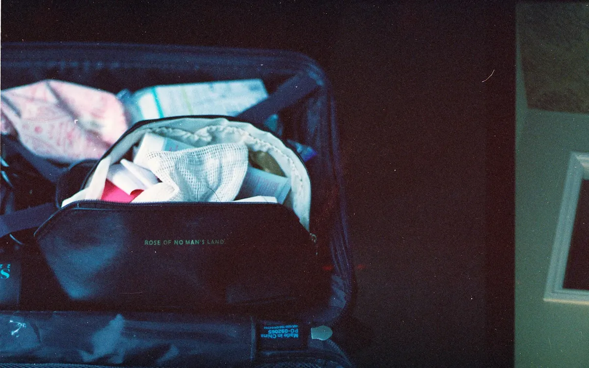 Clothes and toiletries packed tightly inside an open carry-on suitcase
