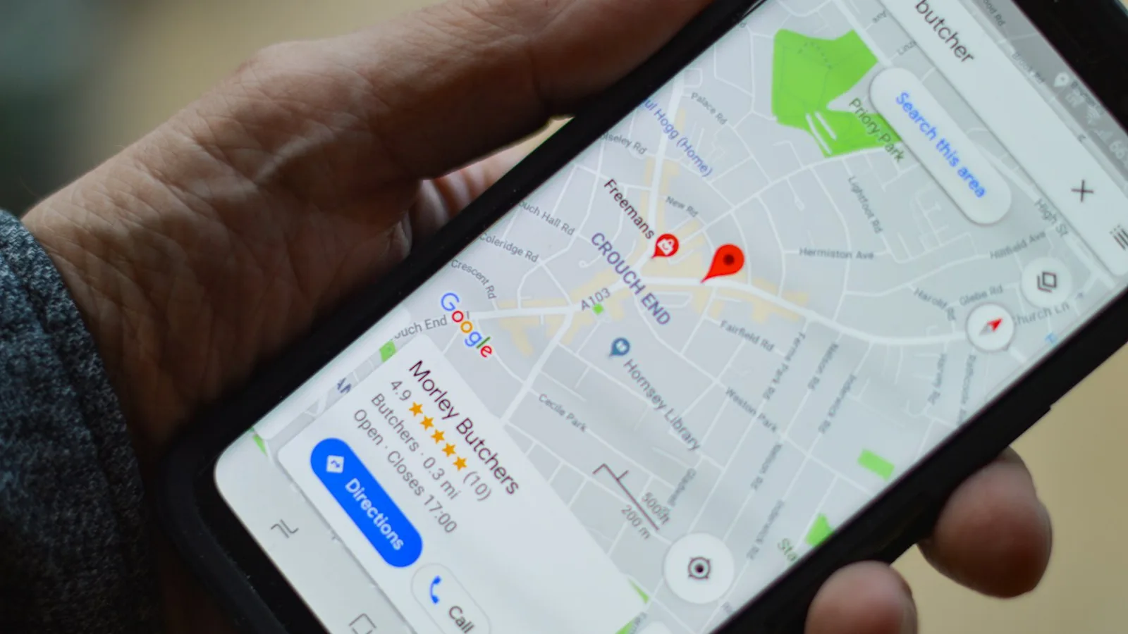 A traveler holding a phone showing an offline map with GPS navigation on a street