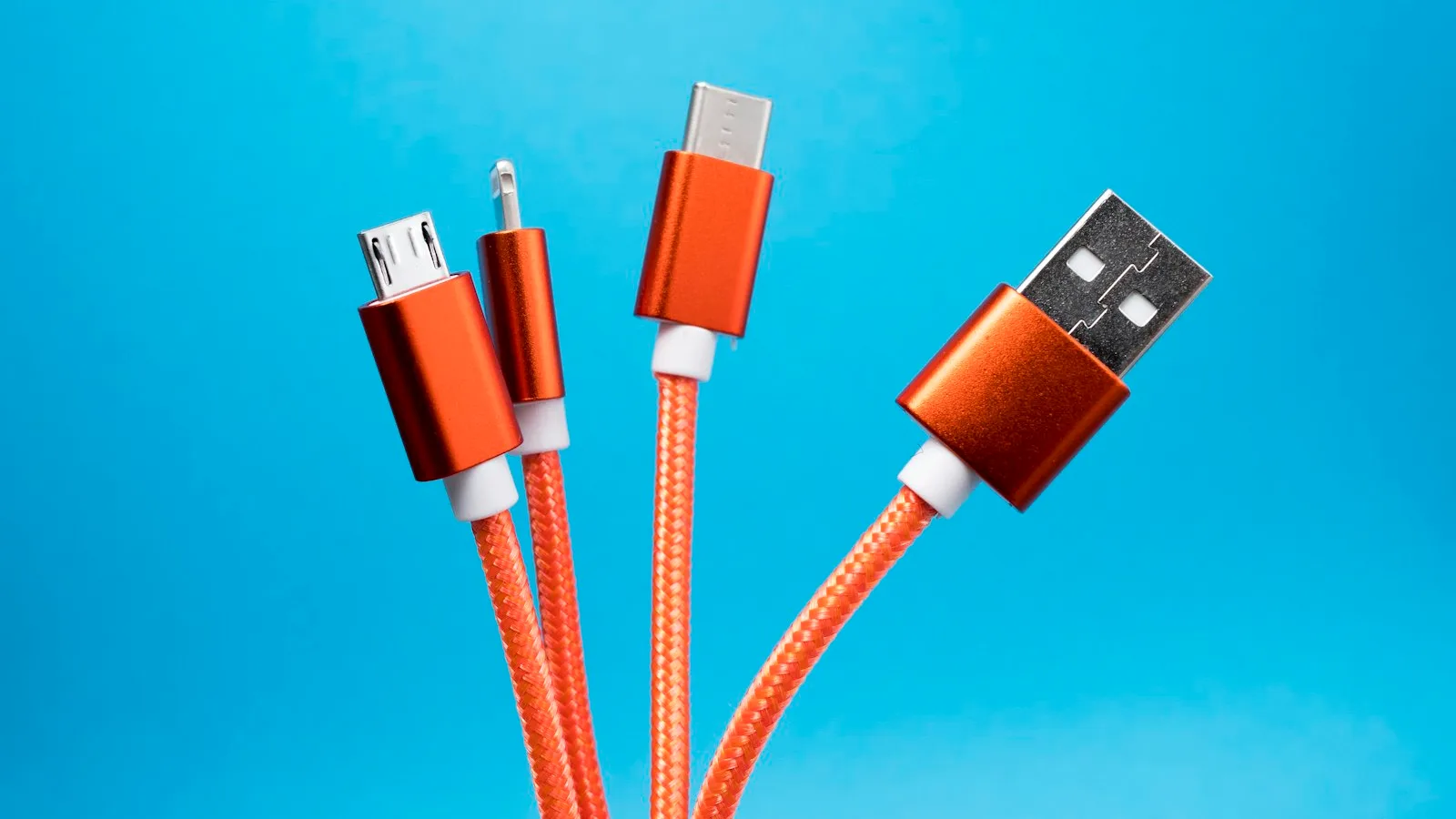 USB-C, USB-A, Lightning and micro-USB charging cable connectors against a blue background